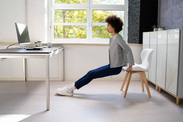 Person performing gentle shoulder stretches at a desk